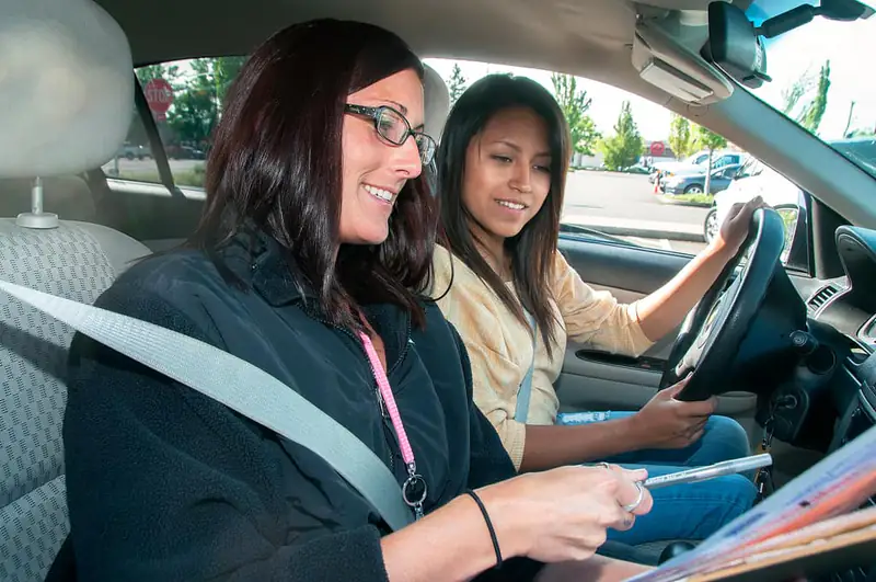Driving test nerves help near Newcastle A smiling learner driver with her instructor, illustrating help with driving test nerves near Newcastle upon Tyne
