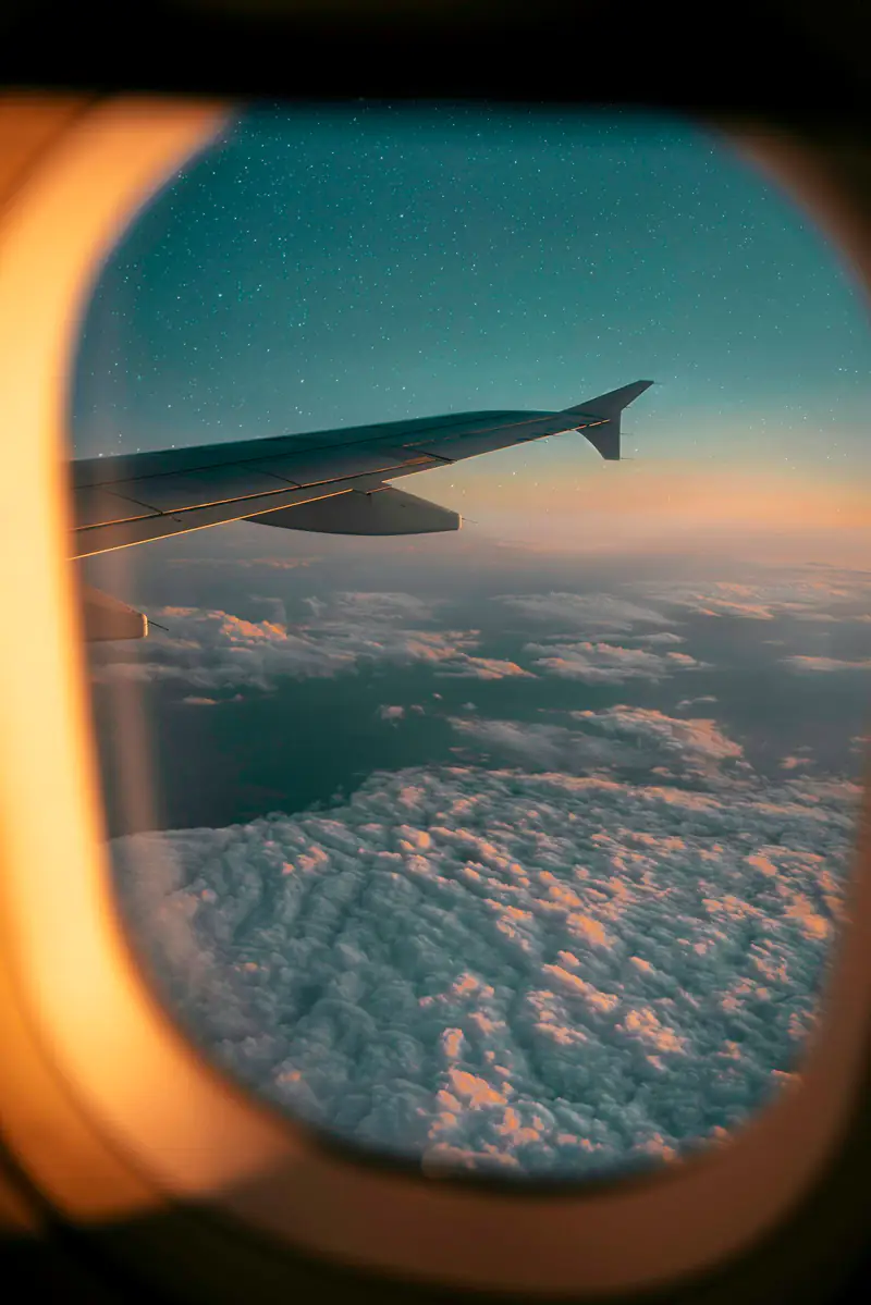 The view of clouds and an aircraft wing from a plane window, illustrating fear of flying help near Newcastle Airport