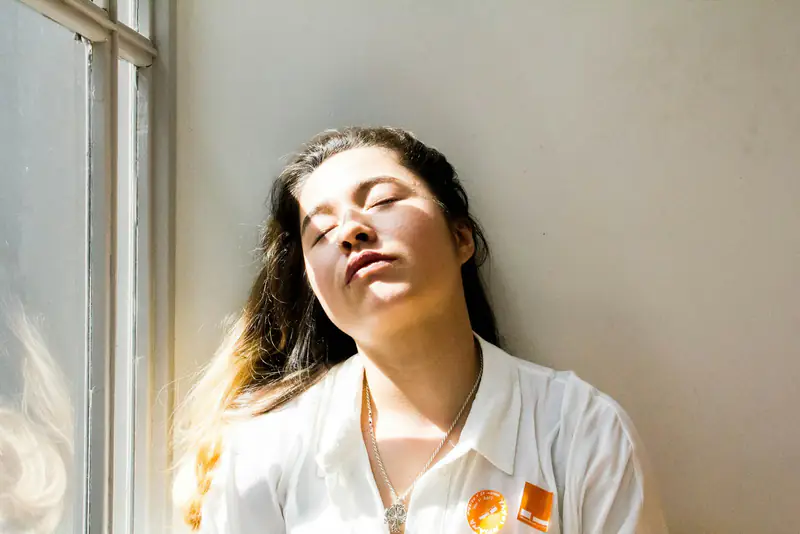 A woman resting with her eyes closed in window light, illustrating support for panic attacks in Wallsend, Newcastle upon Tyne