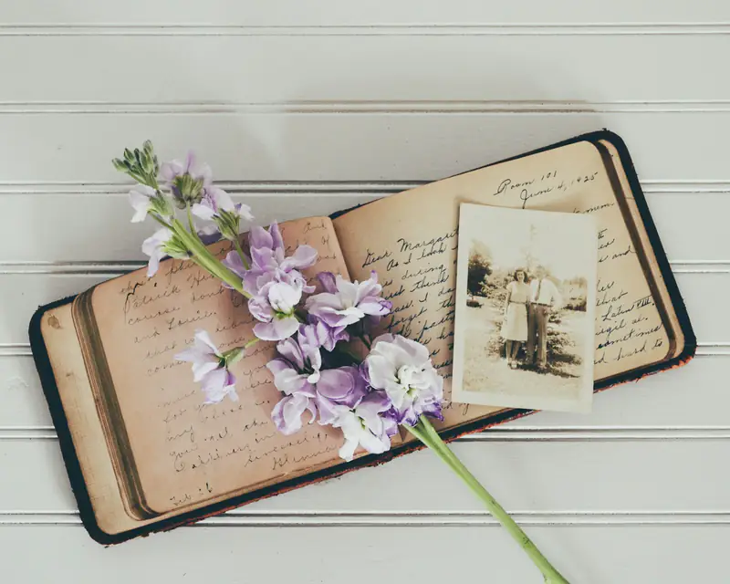 Past life regression in Wallsend, Newcastle An open journal with an old photograph and lavender flowers, representing past life regression sessions in Wallsend, Newcastle upon Tyne
