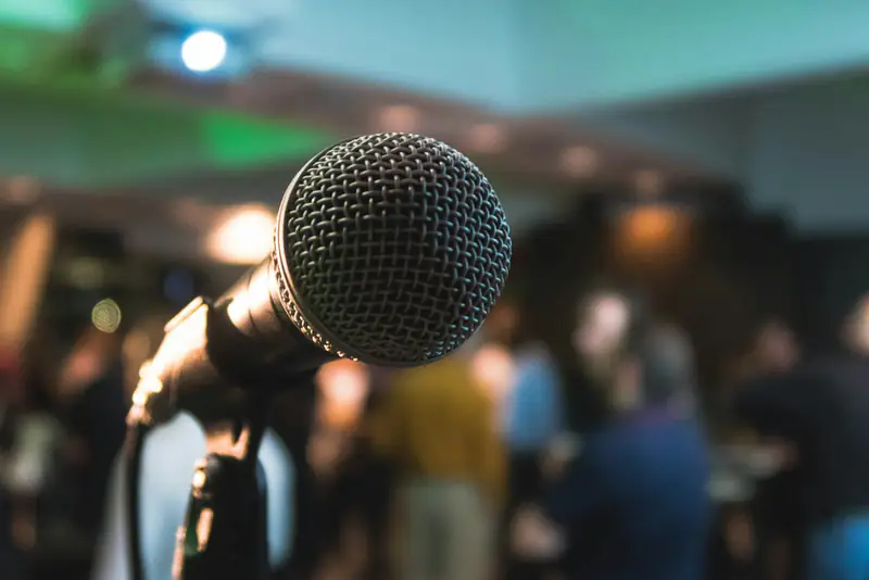 Public speaking nerves help in Wallsend, Newcastle A microphone facing an audience, illustrating help with public speaking nerves in Wallsend, Newcastle upon Tyne